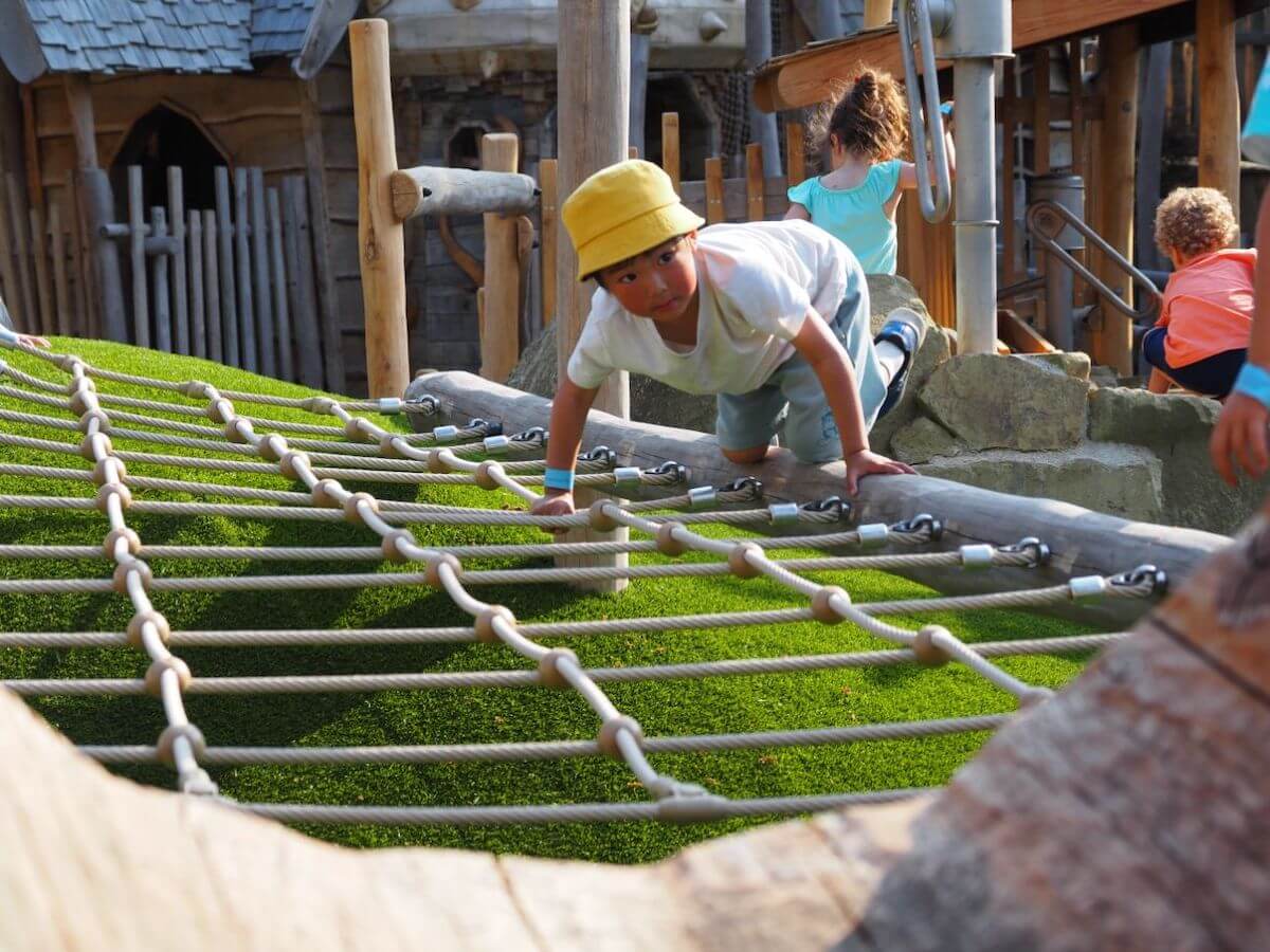 Climbing across the rope play at Courtyard Play for Toddlers at Windsor Great Park