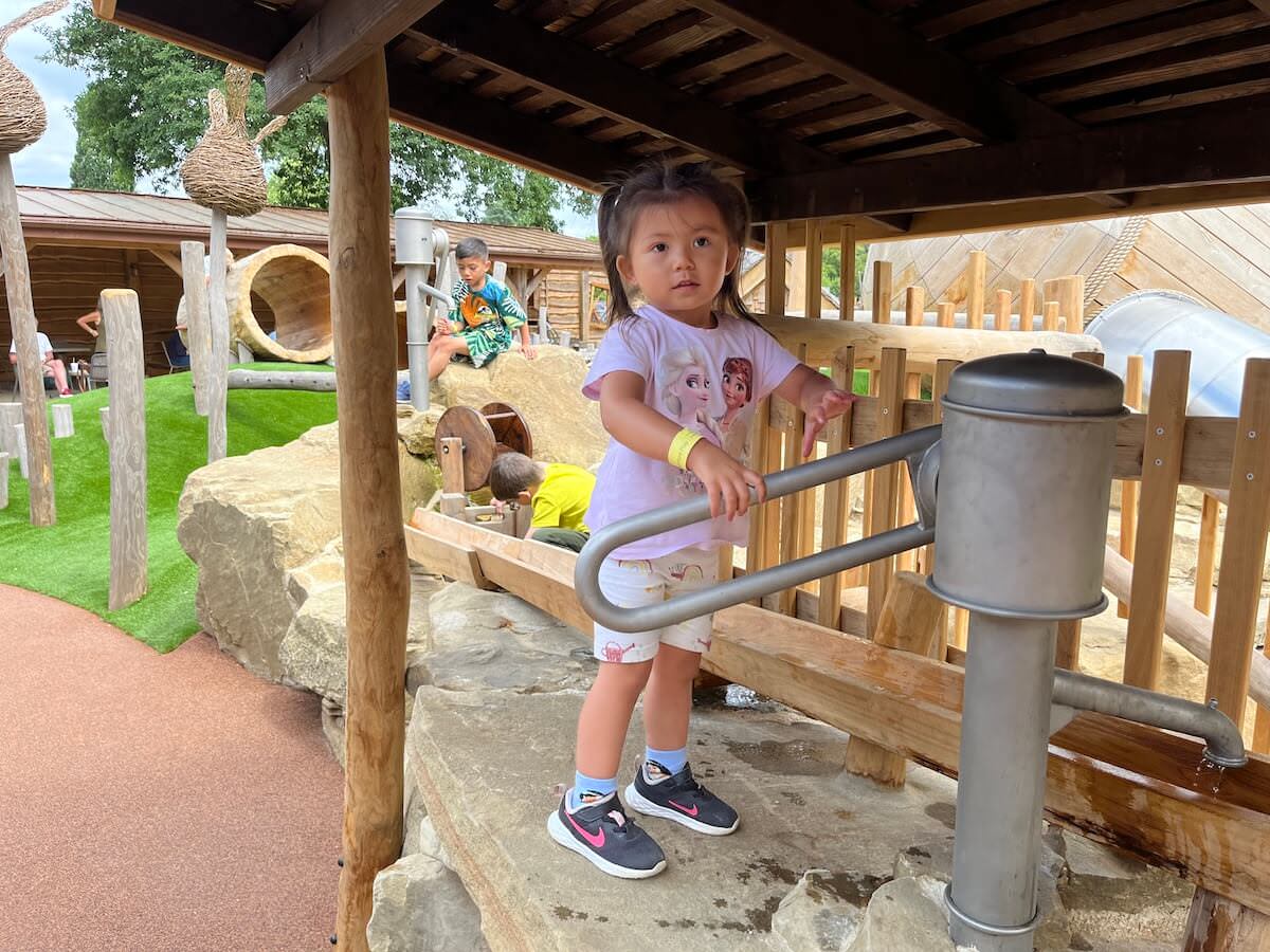 Pumping up the water by hand with the amazing Courtyard Play for Toddlers at Windsor Great Park