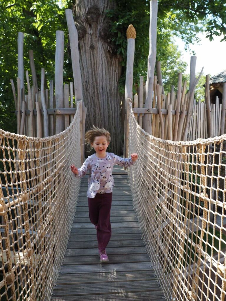 Running across a wobbly bridge at Windsor Great Park Adventure Play