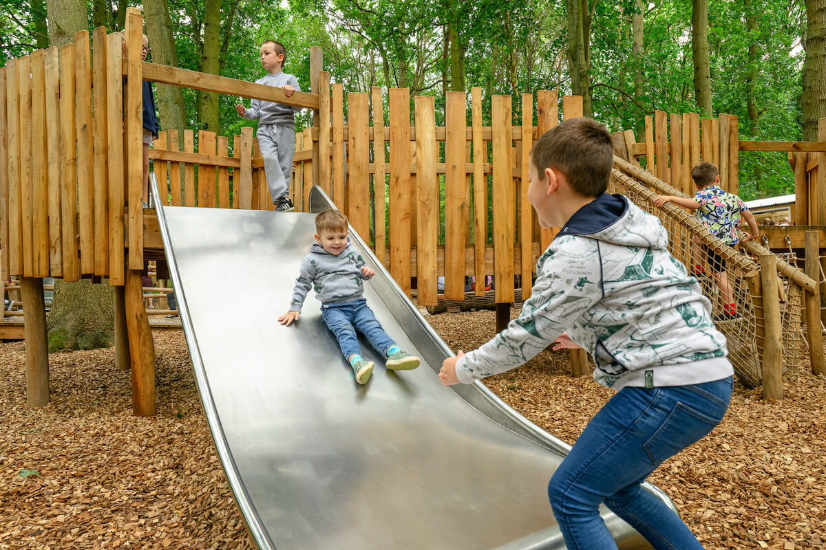 Sliding on the toddler slide at Hermits Hollow at Coombe Country Park with Adventure play by CAP.Co