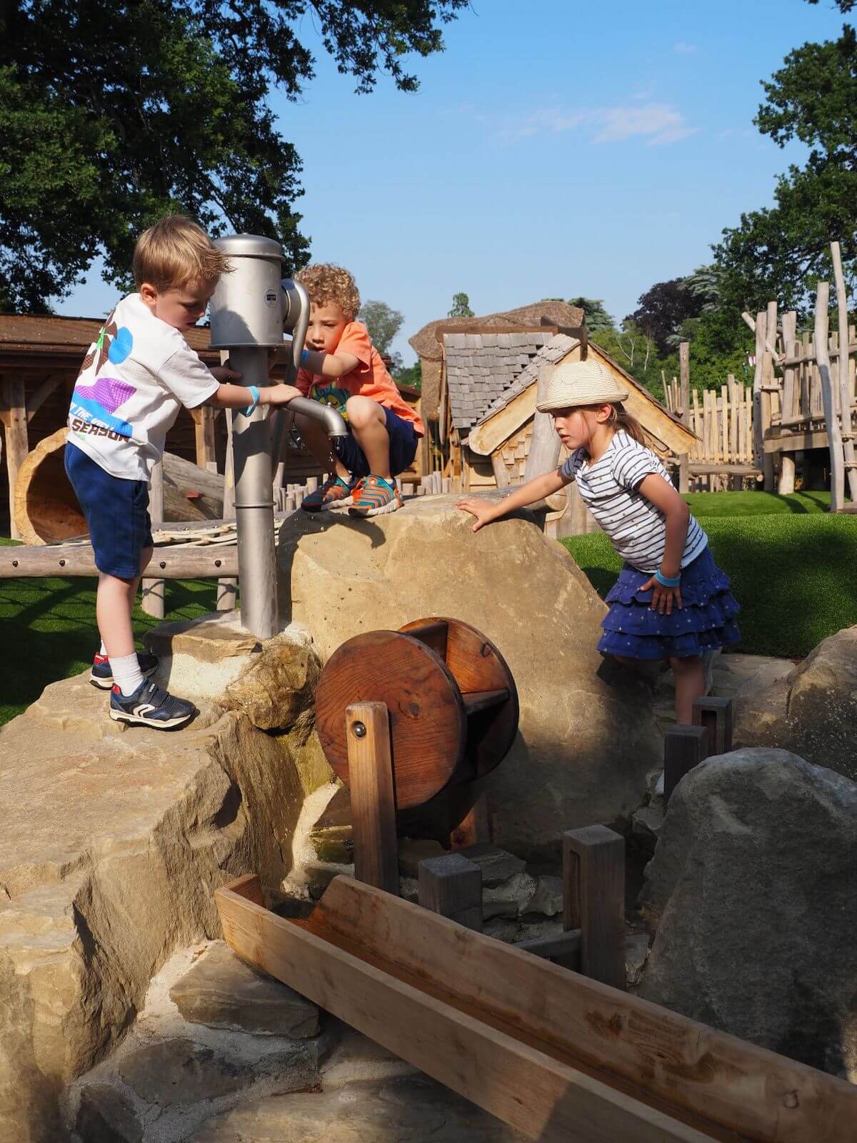 Teamwork to pump water for play together at Courtyard Play for Toddlers at Windsor Great Park