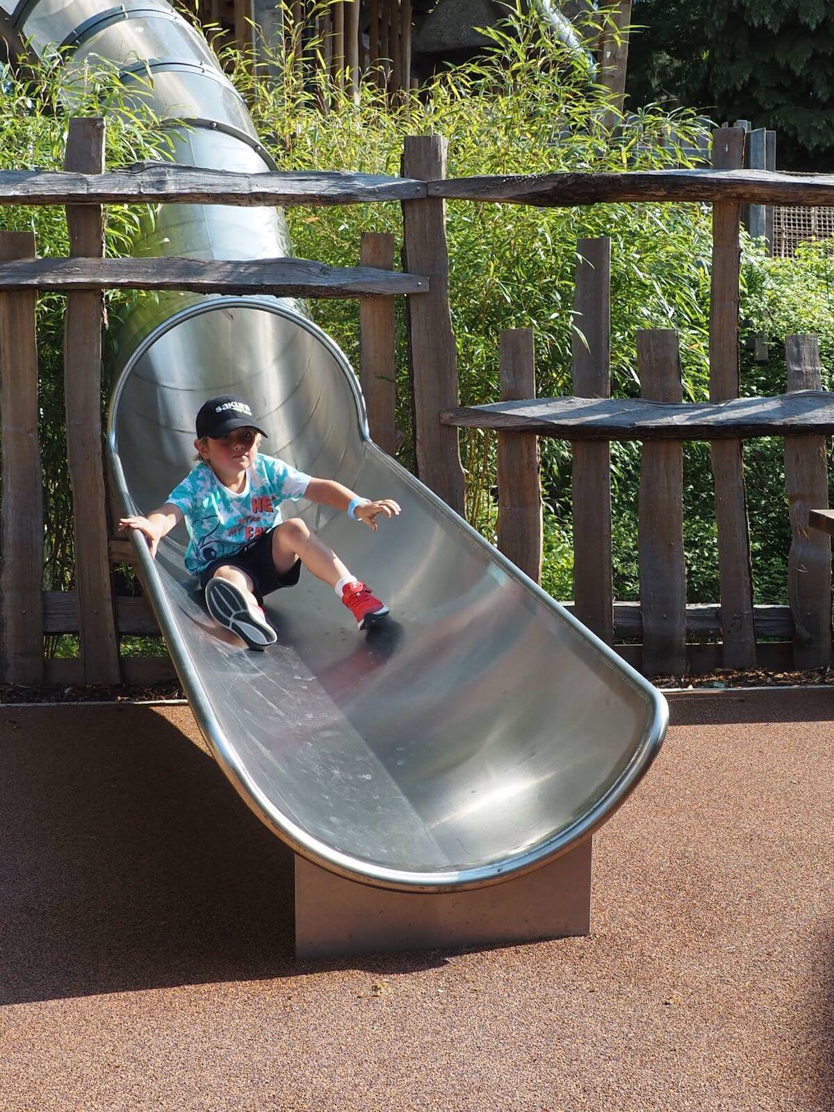 The bottom of the slide onto safety surfacing inside Windsor Great Park Adventure Play