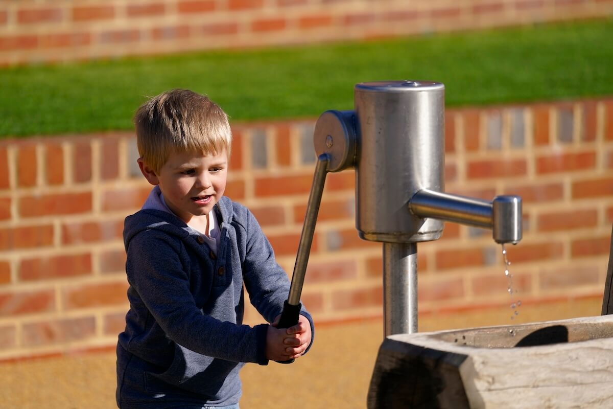 Pumping water at in the play at The Lost Garden within Blenheim Palace Adventure Play by CAP.Co
