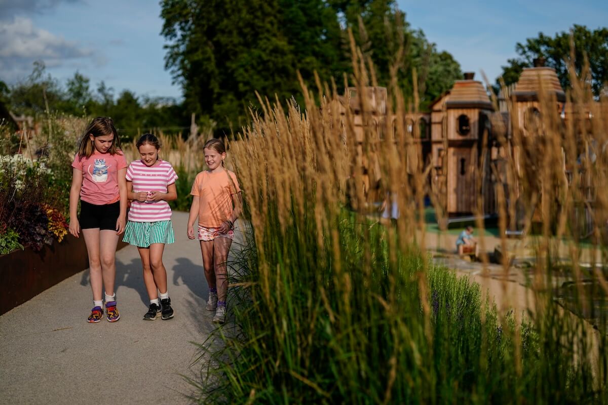 Three kids walking through the undergrowth at The Lost Garden within Blenheim Palace Adventure Play by CAP.Co