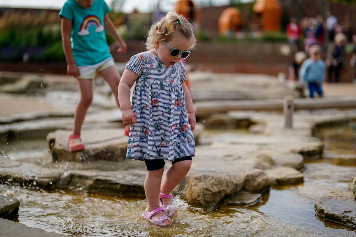 Toddler on the rocks at The Lost Garden within Blenheim Palace Adventure Play by CAP.Co