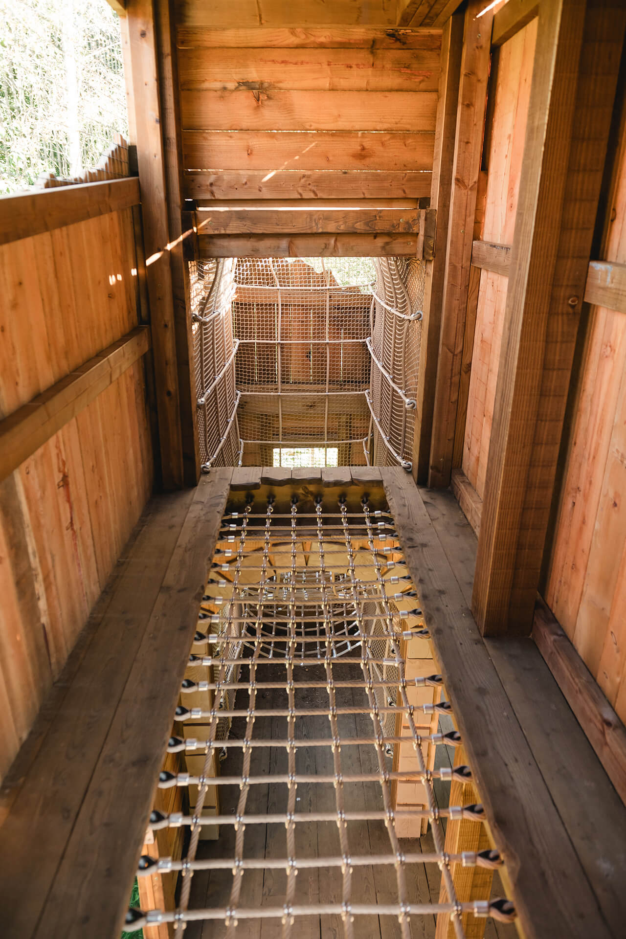 Cargo netting floor leading to climbing net at the CAP.CO built adventure playground at Almond Valley photography by Lindsey Mack