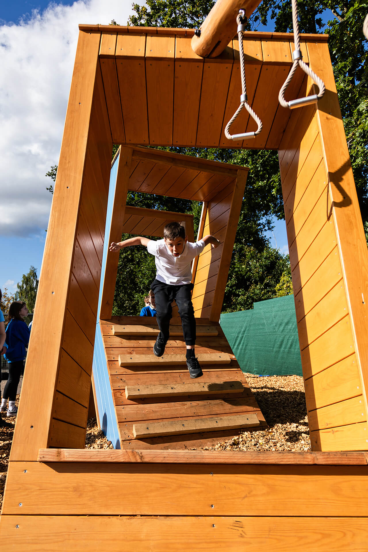 A child jumping through the letters at Poringland school playground built by CAP.CO photography by Kev Foster