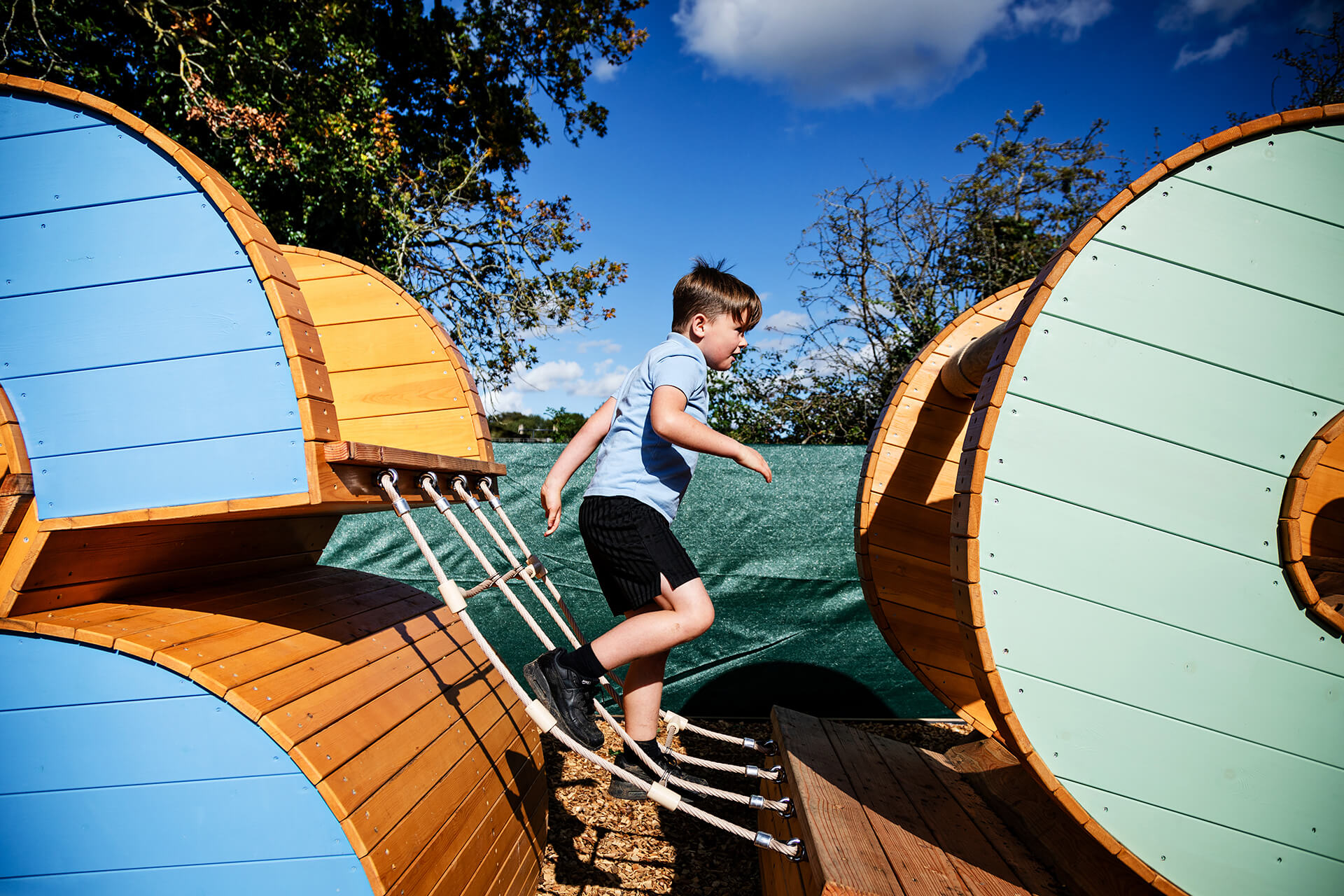 Child climbing through the letters at Poringland school built by CAP.CO photography by Kev Foster