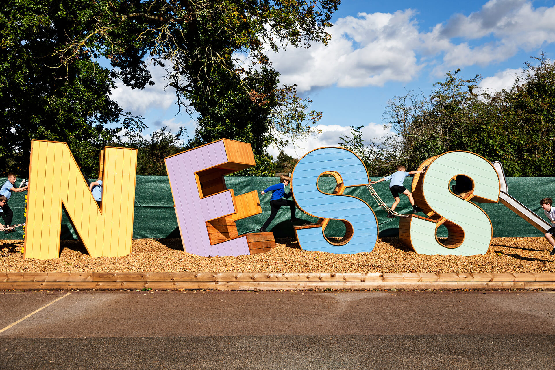 Children climbing on the kindess letters at Poringland school built by CAP.CO photography by Kev Foster