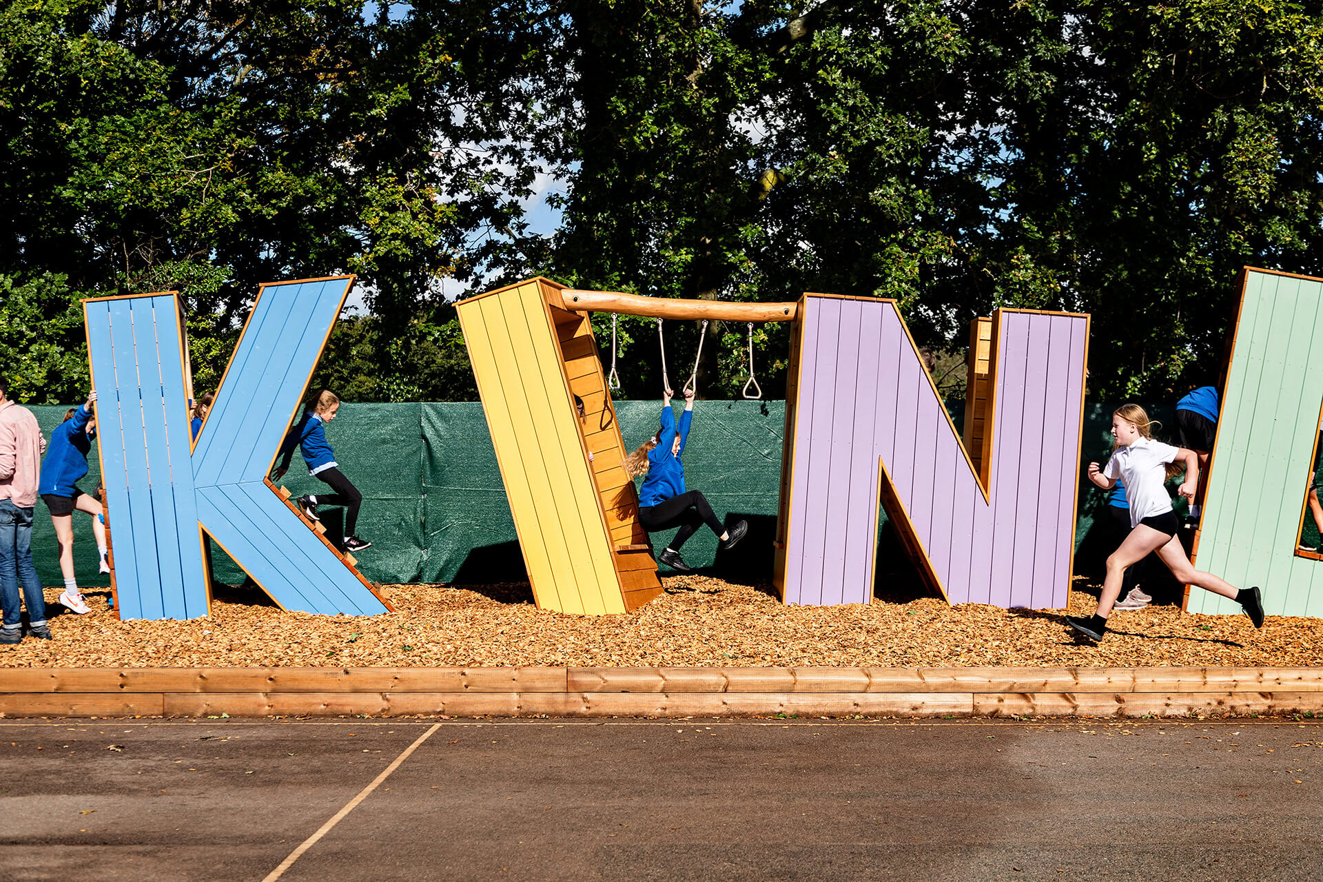 Children swinging through the Kindness letters at Poringland school built by CAP.CO photography by Kev Foster