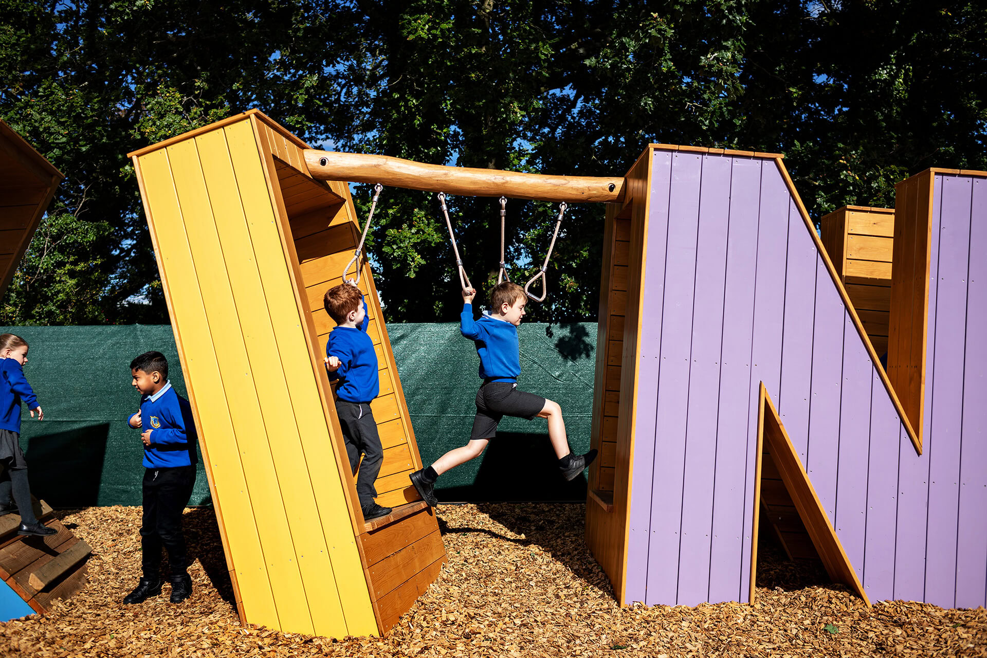 Children swinging through the letters at Poringland school built by CAP.CO photography by Kev Foster