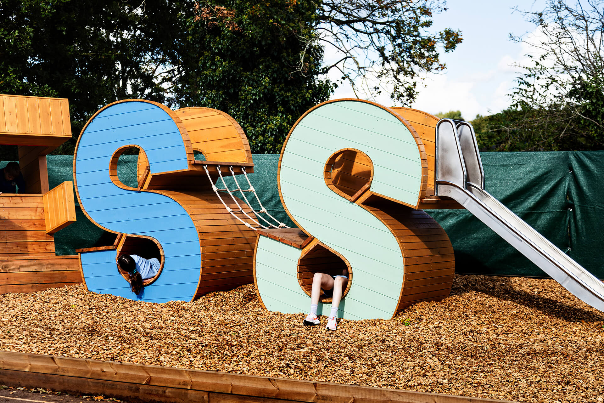 Childrens feet dangling out of the crawl space at Poringland school built by CAP.CO photography by Kev Foster