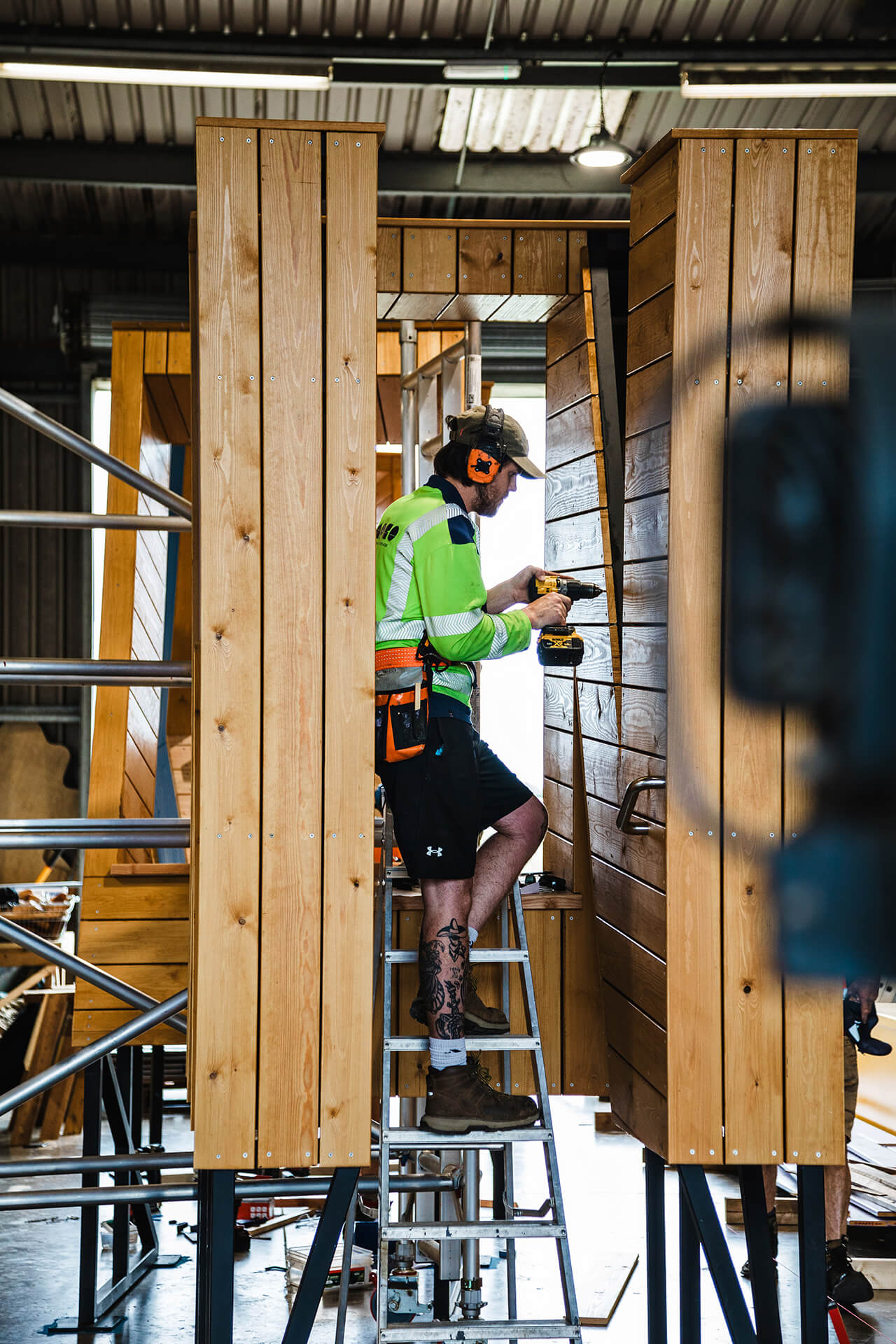 Oli drilling the cladding boards in the CAPCO workshop for Poringland school photography by Kev Foster