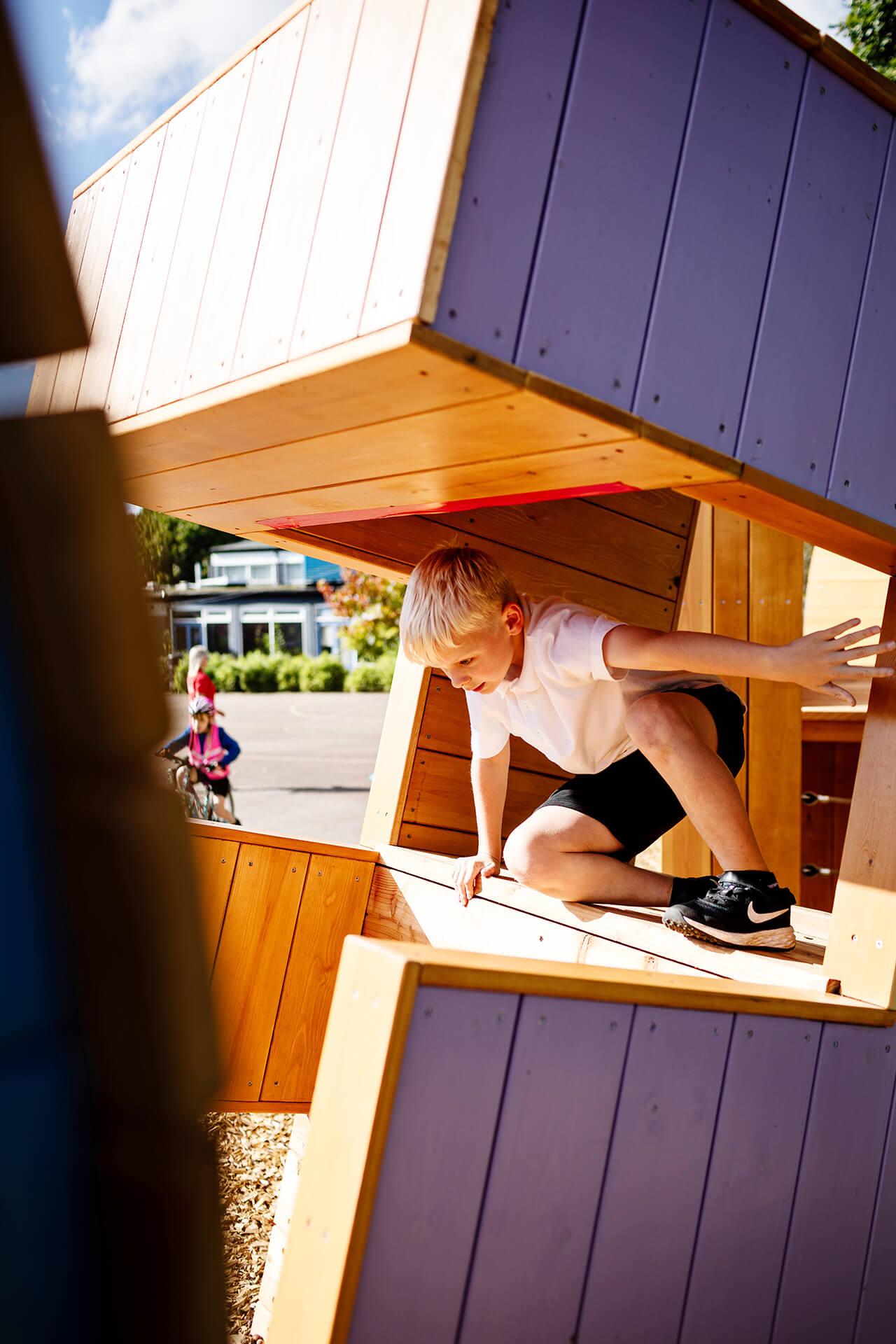 Poringland School Kindness playground built by CAPCO child crouching and climbing through the letters photograpy by Kev Foster
