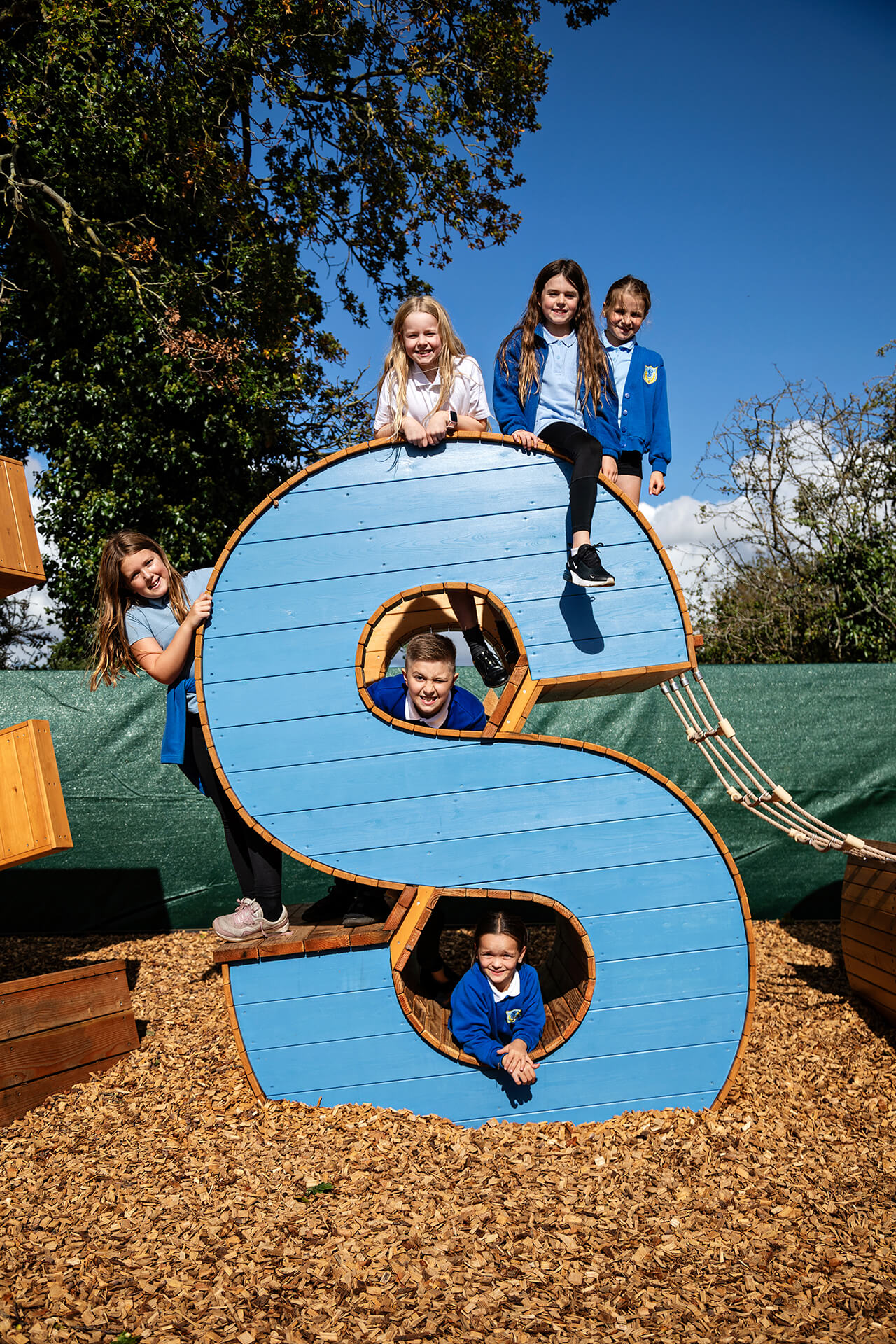 a group of children posing for a photograph on the playground at Poringland school playground built by CAP.CO photography by Kev Foster