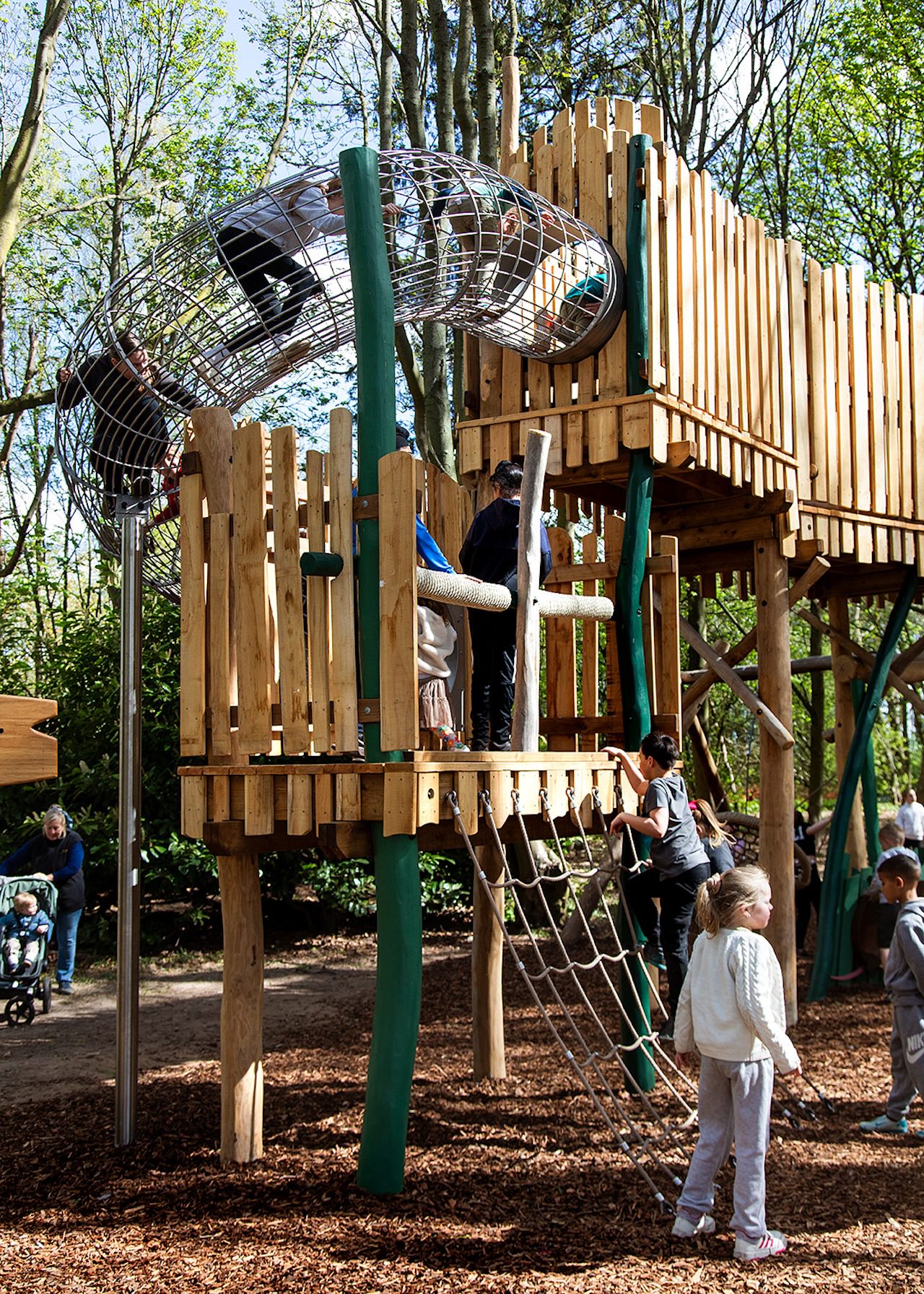 Children climbing the cargo net to the mesh tunnel at the Woodland Adventures playground at The Belfry Hotel built and designed by CAP.CO photography by Kev Foster