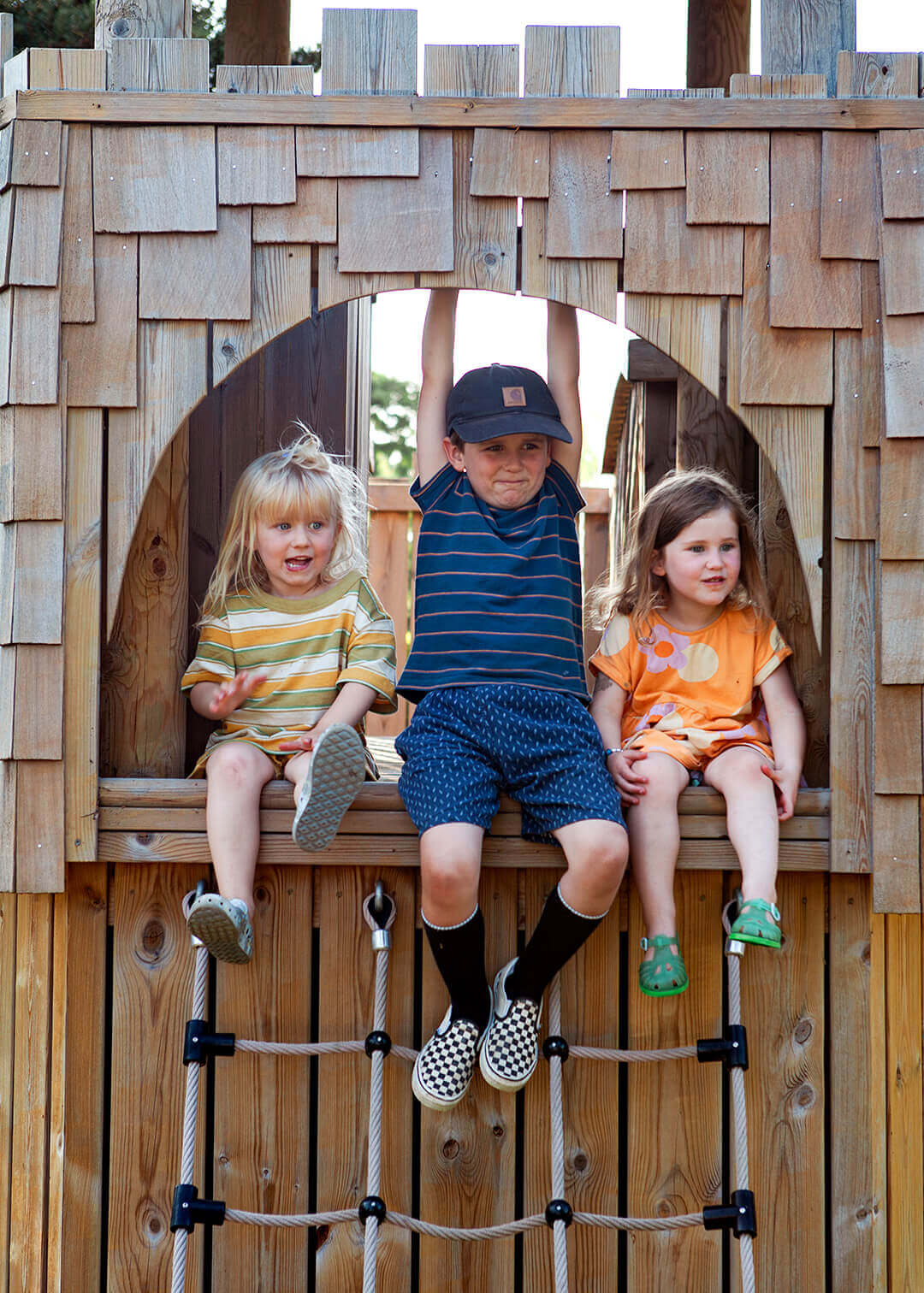 Children sitting at the top of the cargo net at carborough Hill Country Inn Hotel pine tower playground built and designed by CAPCO photography by George Browne