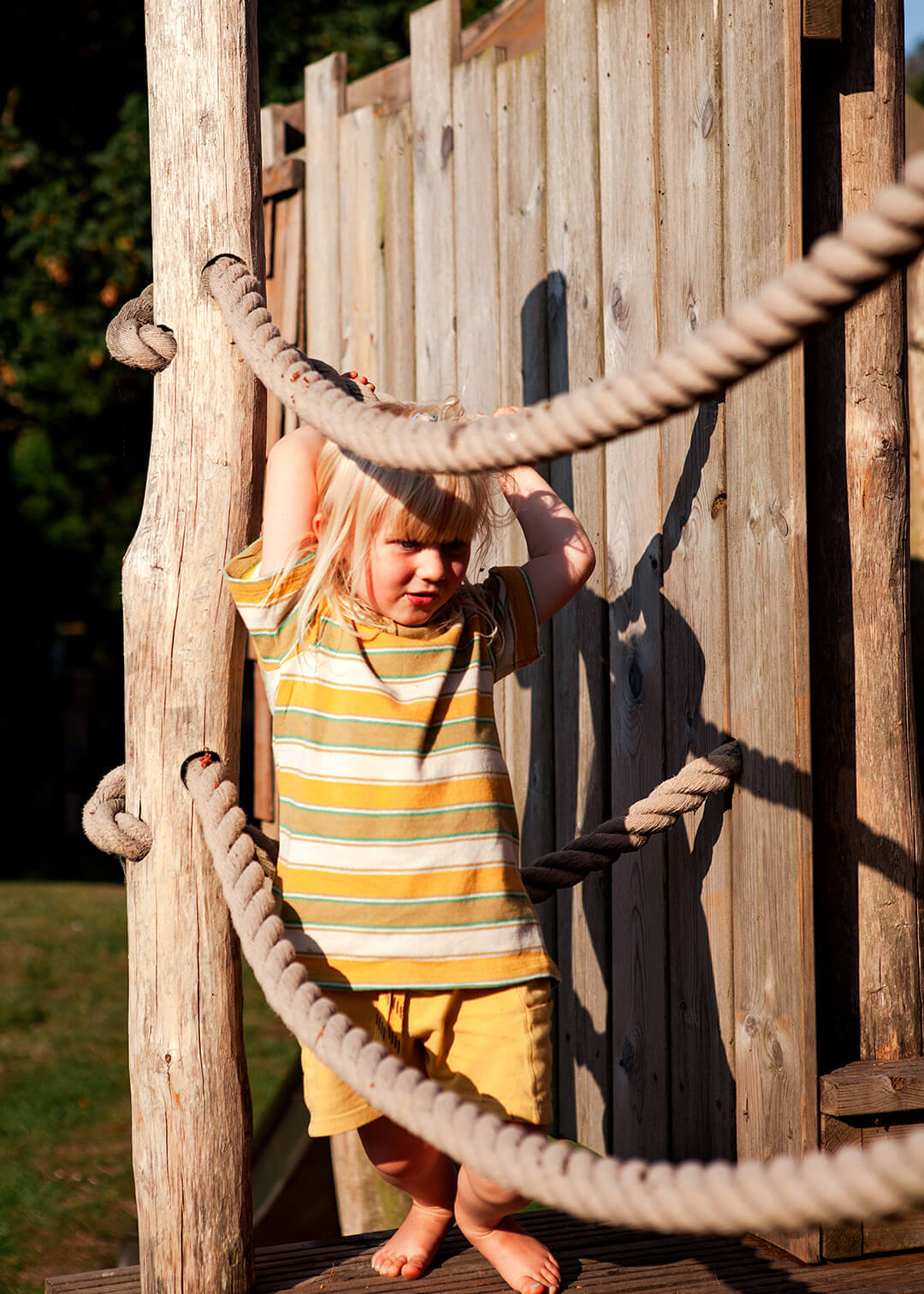 a girl swinging on the rope railings at Scarborough Hill Country Inn Hotel pine tower playground built and designed by CAPCO photography by George Browne