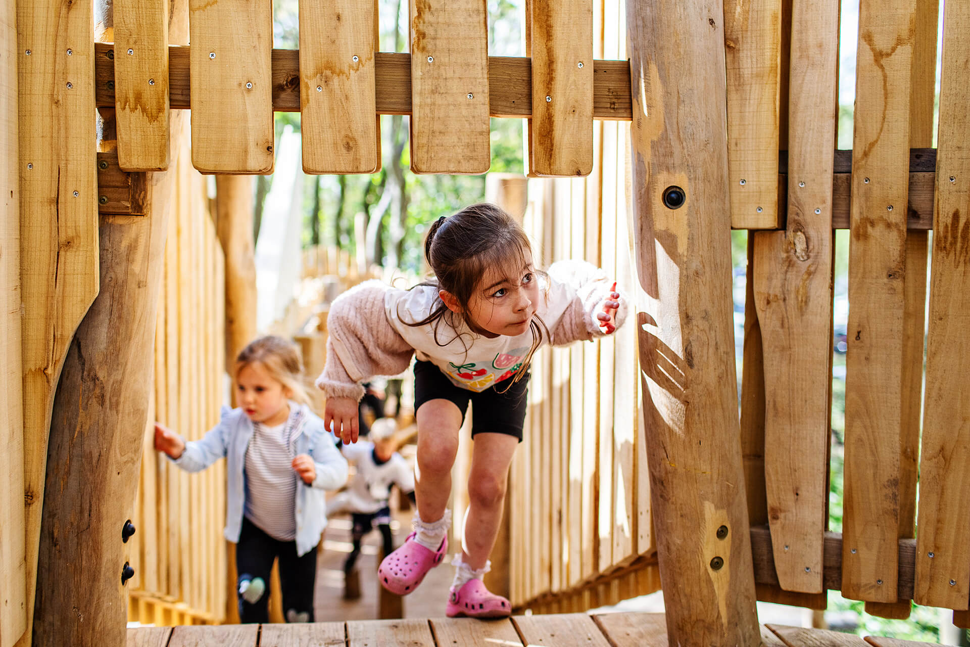 A little girl makes it to the top of the main tower on the Woodland Adventures playground at The Belfry Hotel built and designed by CAP.CO photography by Kev Foster