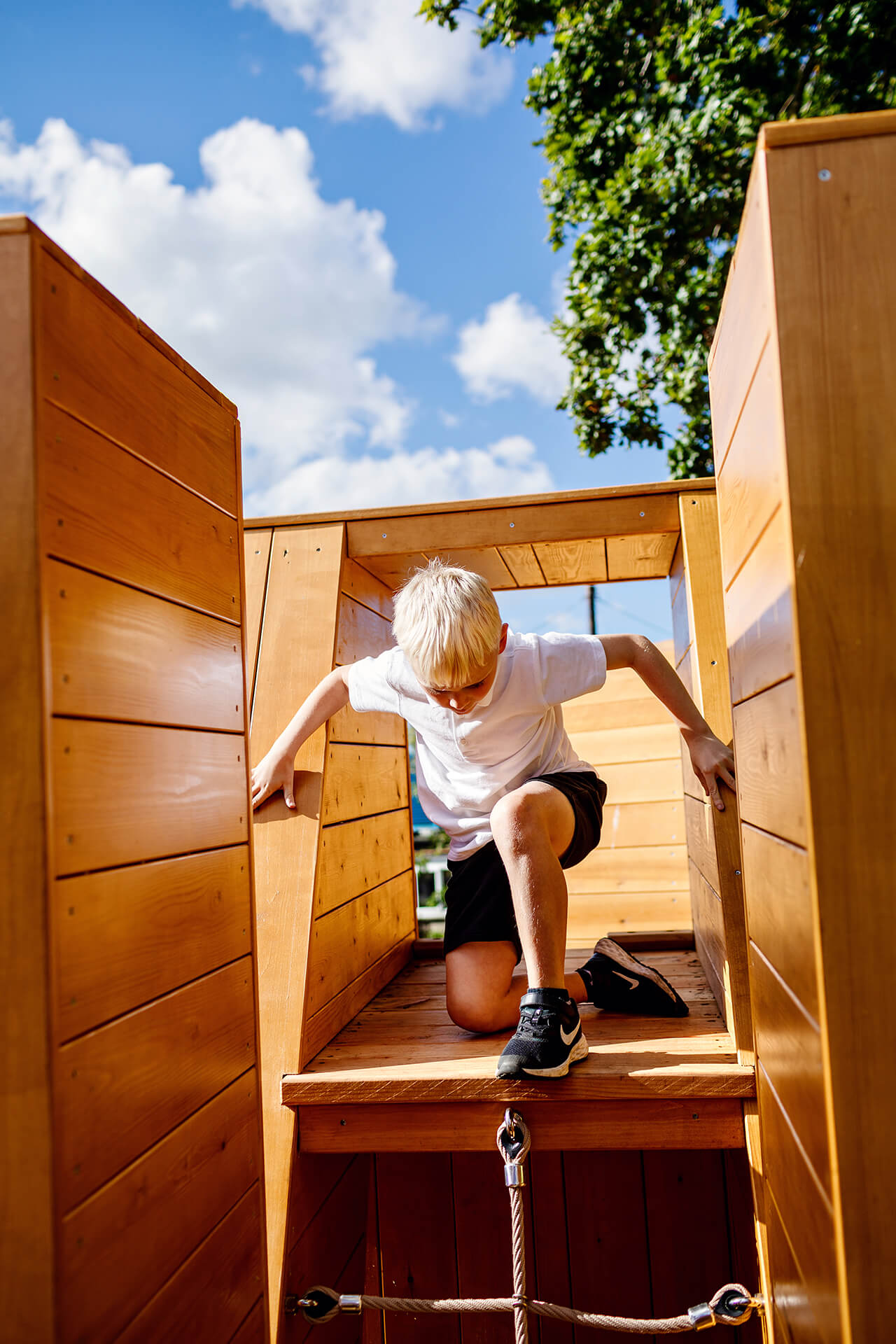 Poringland School Kindness playground built by CAPCO child climbing through the letters photography by Kev Foster