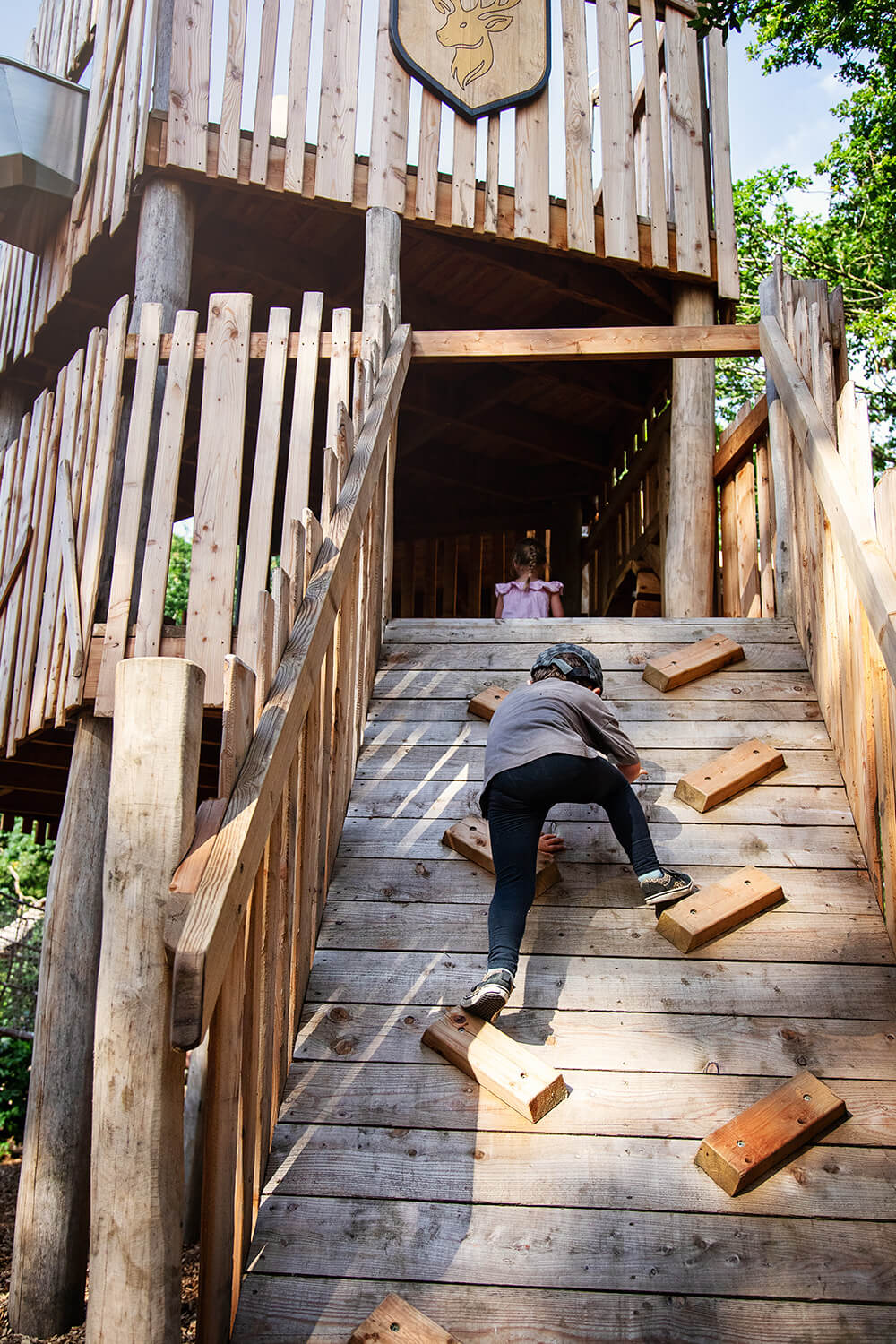 A child climbing the ramp at Guildenacre adventure playground at Helmingham designed and built by CAP.CO, photography by Kev Foster