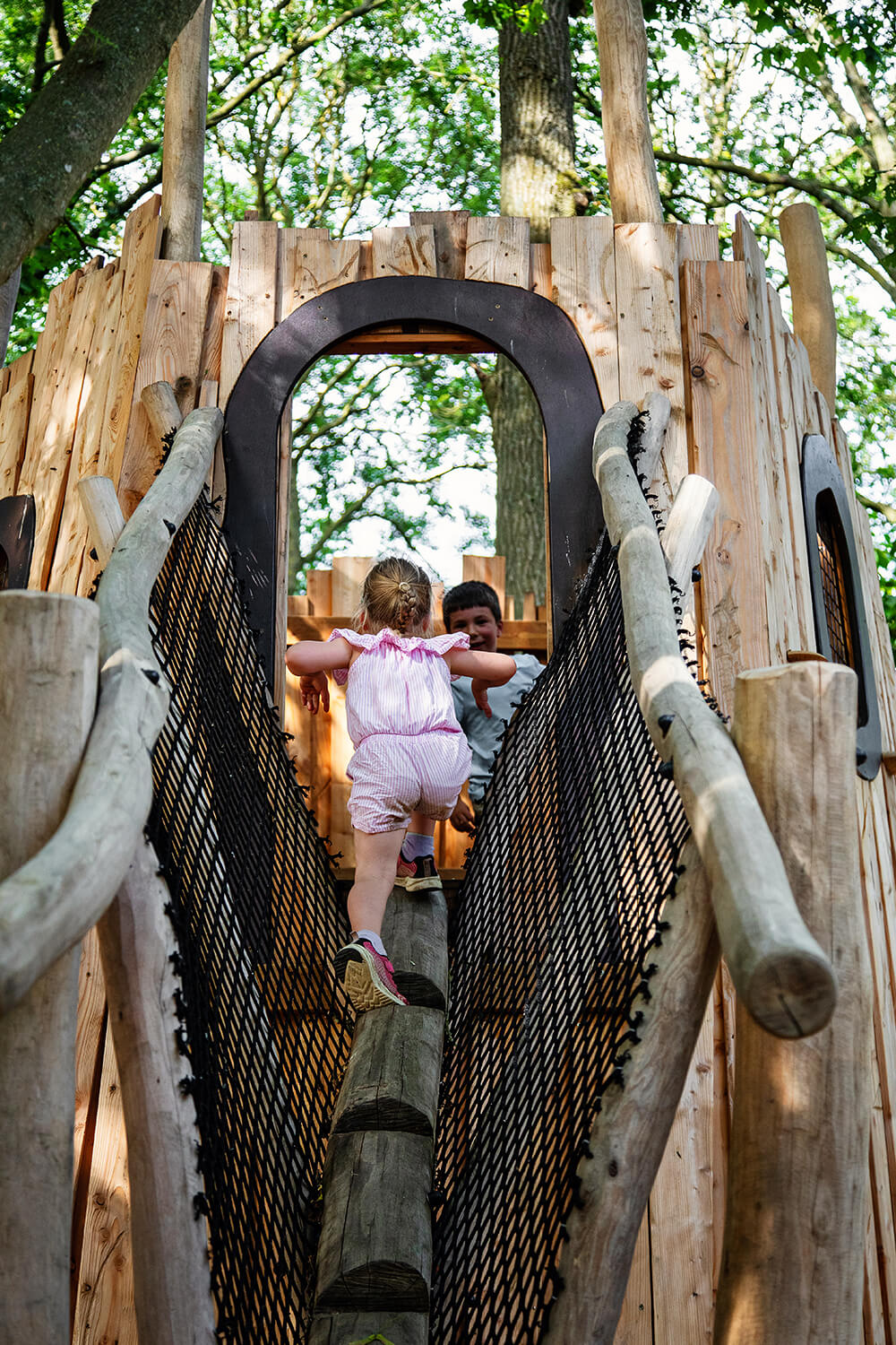 Climbing into Vex's Ember den at the Guildenacre adventure playground at Helmingham designed and built by CAP.CO, photography by Kev Foster