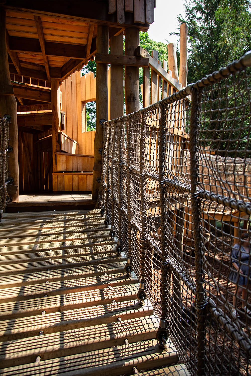 A wobbly cargo net bridge connecting the structures on The Sky Maze adventure playground at Cotswold Wildlife Park, designed and built by CAP.CO, photography by Kev Foster