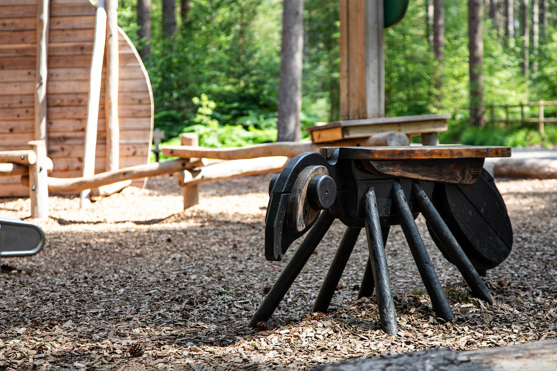 Bespoke timber play structures designed by CAP.CO and surrounded by mature trees at Ants’ Nest