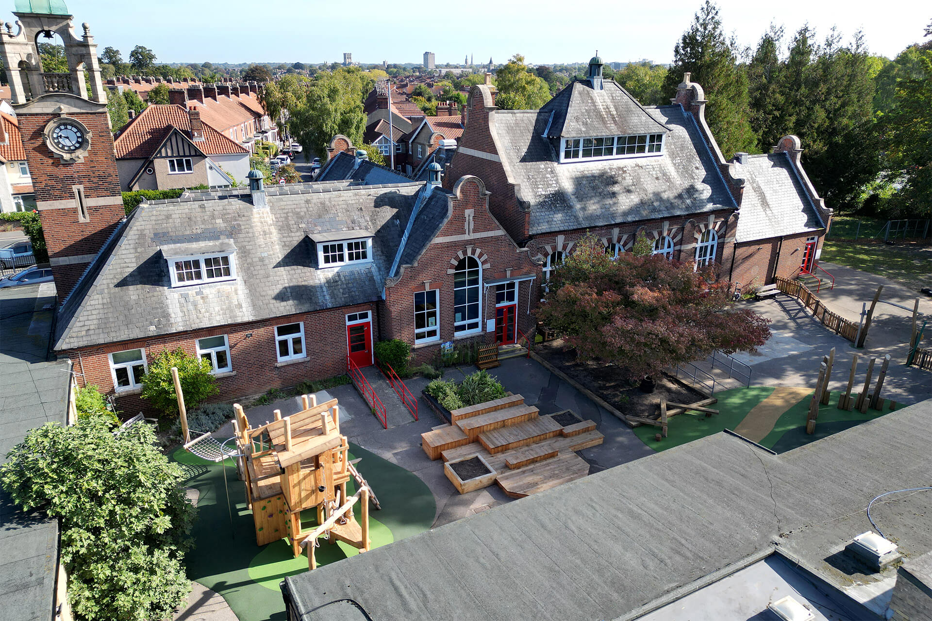 Aerial view of the new play courtyard at Colman Infant School, Norwich, with play tower, outdoor classroom decks and ground play, designed and built by CAP.CO. Photography by George Browne