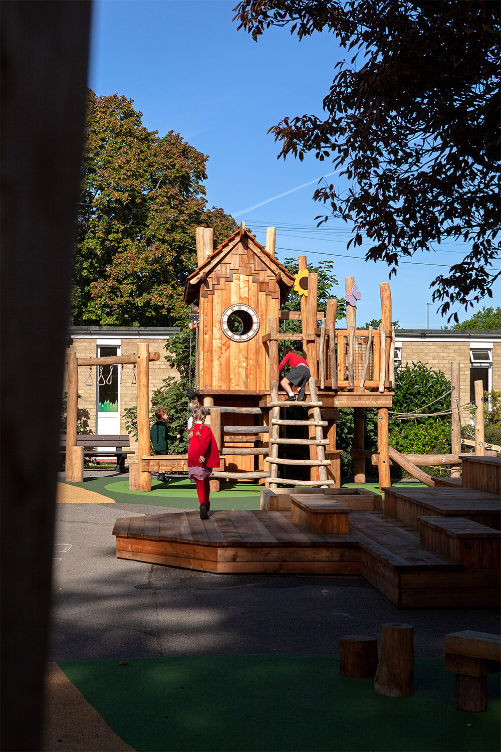Child running across the performance deck towards the play tower at Colman Infant School, designed by CAP.CO. Photography by George Browne