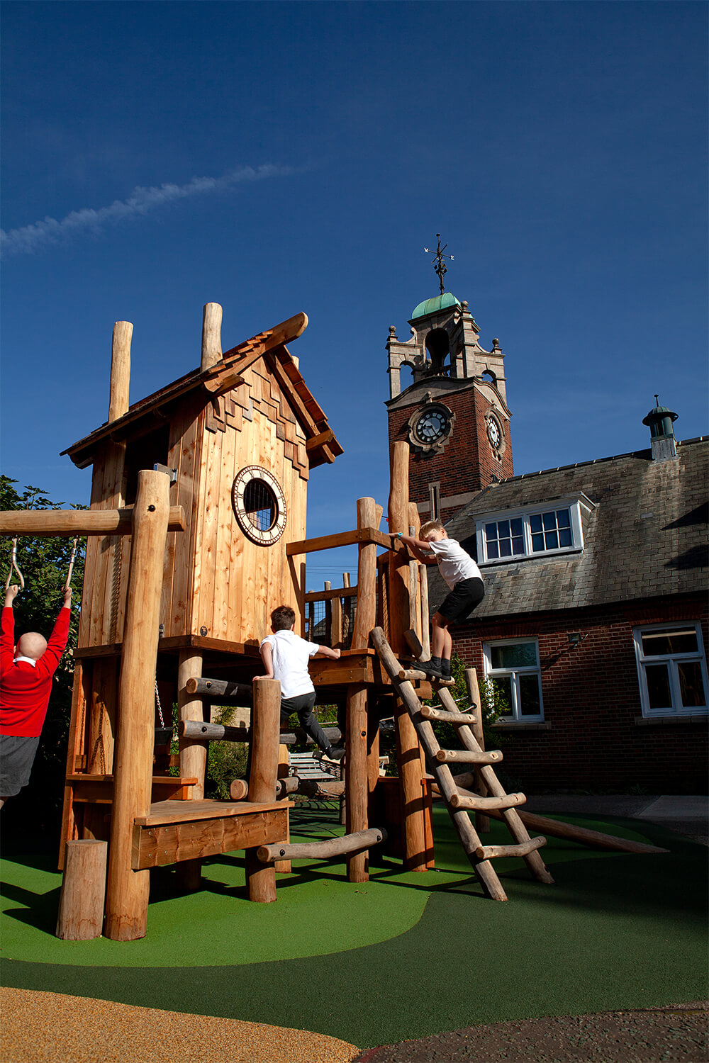 Children climbing the play tower with the Colman school clock tower behind, designed by CAP.CO. Photography by George Browne