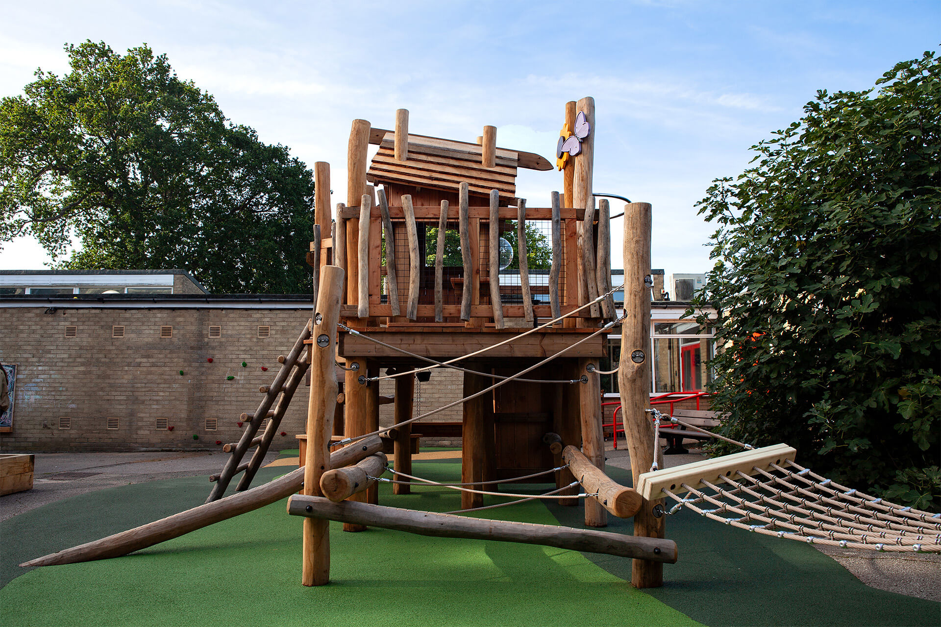 Rope bridge, hammock swing seat and log ladder around the play tower at Colman Infant School, Norwich, by CAP.CO. Photography by George Browne