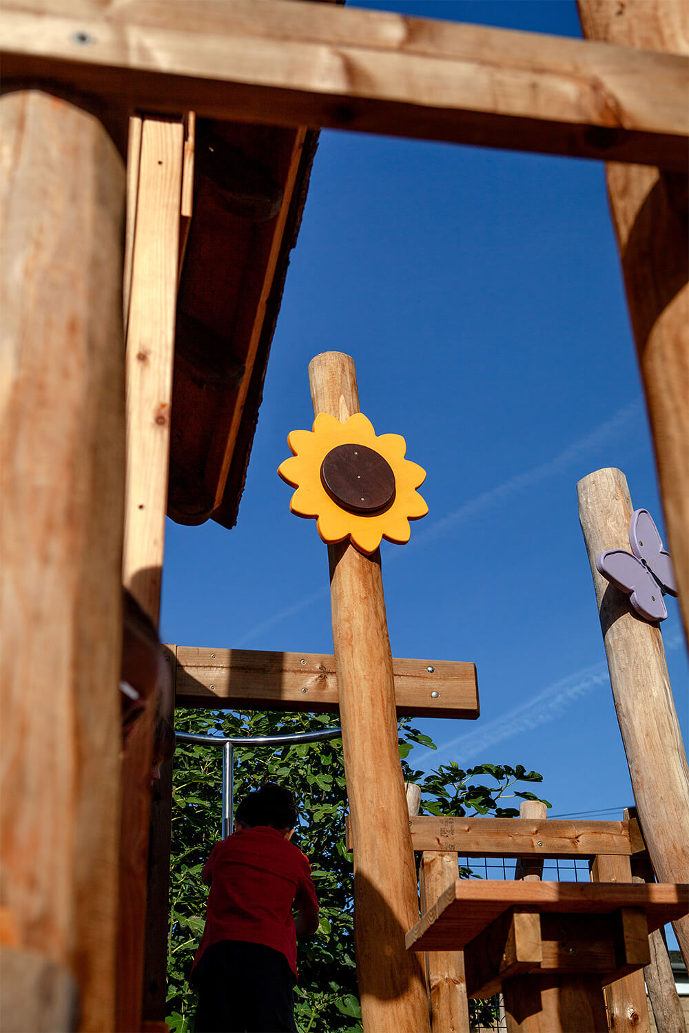 Sunflower and butterfly sculptural details on robinia posts of the play tower at Colman Infant School, designed by CAP.CO. Photography by George Browne